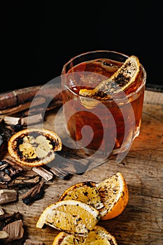 Smoked old fashioned cocktail on dark wooden background