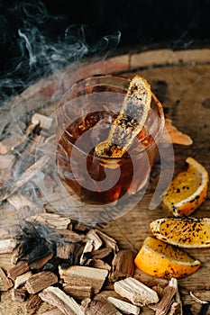 Smoked old fashioned cocktail on dark wooden background