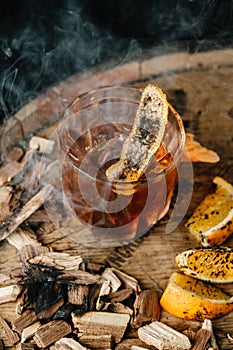 Smoked old fashioned cocktail on dark wooden background