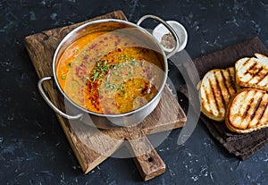 Smoked paprika vegetarian lentil soup with grilled cheese sandwiches a dark background, top view. Delicious comfort food concept
