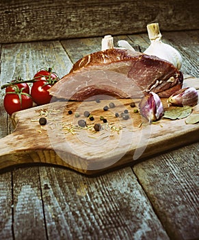 Smoked pork with herbs and spices on wooden board