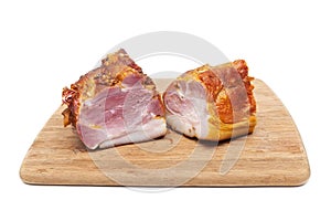 Smoked pork neck on a wooden cutting board on white background
