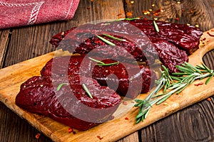 Smoked red deer maral filleted on a wooden background