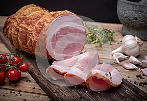 Smoked rolled bacon, pancetta, pork meat roulade, on wooden boards. Composition with Polish cold cuts, meat products.