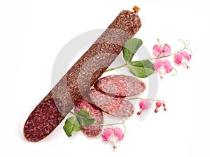Smoked salami decorated with flowers over white ba
