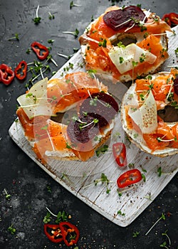 Smoked salmon bagel toasts with soft cheese, cucumber ribbons and beetroot and dill, cress salad