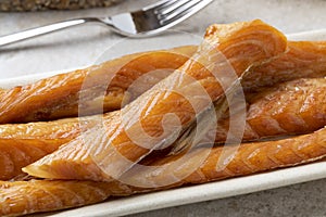 Smoked salmon bellies on a plate close up