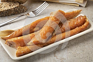 Smoked salmon bellies on a plate close up