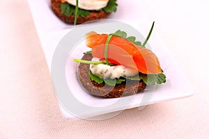 Smoked salmon roll on pumpernickel bread with remoulade