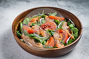 Smoked salmon salad with arugula, tomato and green vegetables. White background. Top View