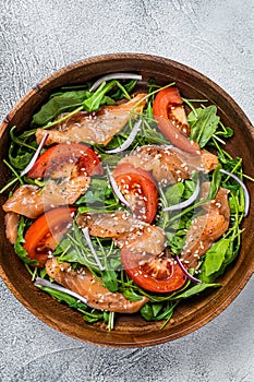 Smoked salmon salad with arugula, tomato and green vegetables. White background. Top View