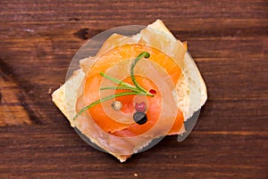 Smoked salmon on toasted bread on wood from above