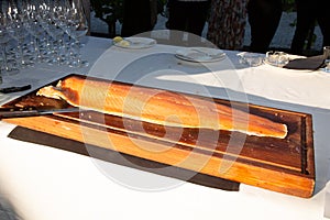 Smoked salmon on wooden cutting board in outdoor party