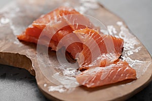 Smoked salted salmon slices on wood board