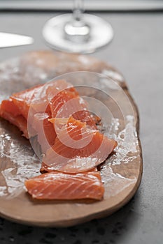 Smoked salted salmon slices on wood board