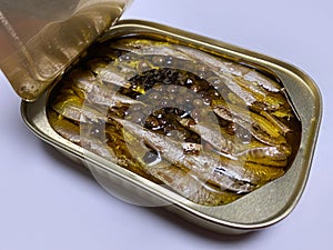 Smoked Sardine with olive oil and black pepper in an open tin can isolated on a white background