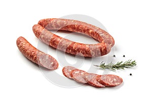 Smoked sausage salami with slices isolated on white background with herbal and pepper clipping path and full depth of field