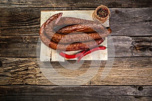 Smoked sausage on a wooden rustic table, natural product from organic farm, top view Food recipe background. space for text