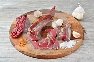 Smoked, sliced pork meat on dark wooden chopping board