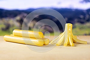 Smoked slovak string cheese stick with alps behind