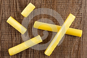 Smoked slovak string cheese stick on brown wood