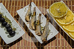 .Smoked Sprats with lemon and black oliven photo