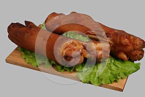 Smoked trotters on wooden board.