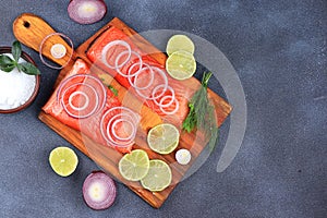 Smoked trout with salmon, red fish steak, served with herbs, onions, lemon. Salmon cooking, seafood, healthy natural food,