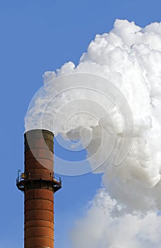 Smokestack Belches Out Smoke Against Blue Sky Vertical