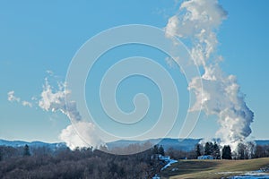 Smokestack emissions from coal fired powerplants photographed against a rural West Virginia backdrop