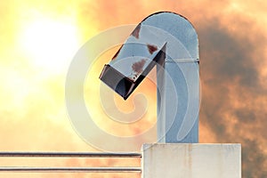 Smokestack, flue, chimney of industrial factory on orange sky pollution and sun light