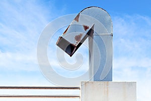 Smokestack, flue, chimney of industrial factory on sky blue