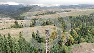 Smokestack. High pipe of burning waste plant surrounded by mountain forest