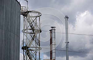 Smokestack of an industrial plant against a blue sky with clouds