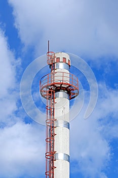 Smokestack with ladder on the sky background