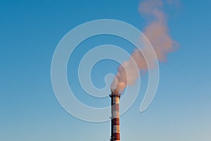 Smokestack and smoke against blue sky. Environmental pollution
