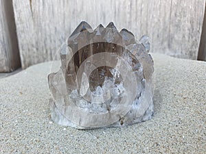 Smokey Quartz on Sand with Wood on Background on the Beach