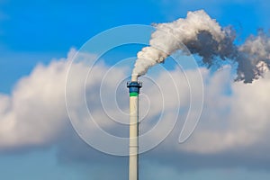 Smoking chimney against the blue sky