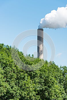 Smoking chimney against a bright blue sky