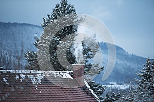 Smoking chimney of a house in winter