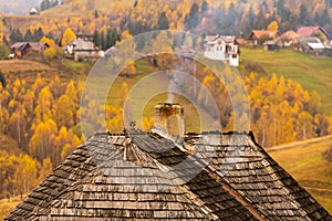 Smoking chimney on a roof of a traditional wood house in Romania