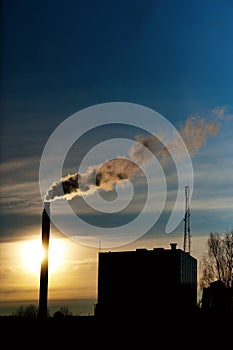 Smoking chimney at sunset