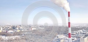 smoking chimney of a thermal power plant on the background of winter city