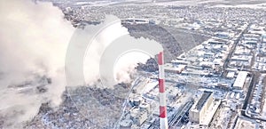 smoking chimney of a thermal power plant on the background of winter city