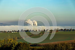 Smoking chimneys in from factory hidden in mist