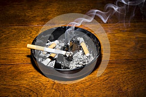 Smoking cigarette in ashtray