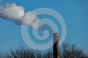 Smoking EC tower of a large chemical plant in Rhineland, Germany. White smoke from chimney against a blue sky. pollution icon