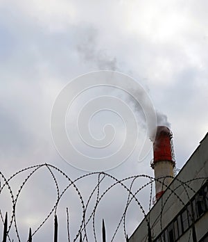 Smoking factory chimney in an industrial zone