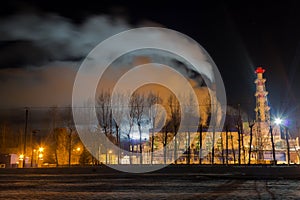 The smoking factory pipes at night. Winter city landscape. Night shooting.