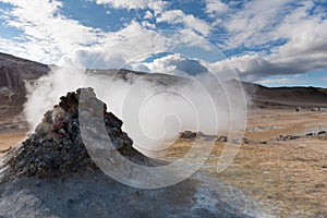 Smoking fumarole near Hverir geothermal area, Myvatn Lake area, Iceland. Geothermal area with smoking fumaroles and mud geothermal